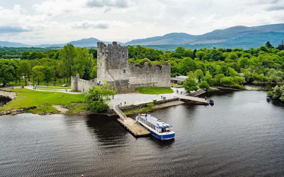 A lakeside tower house and tour boat in County Kerry