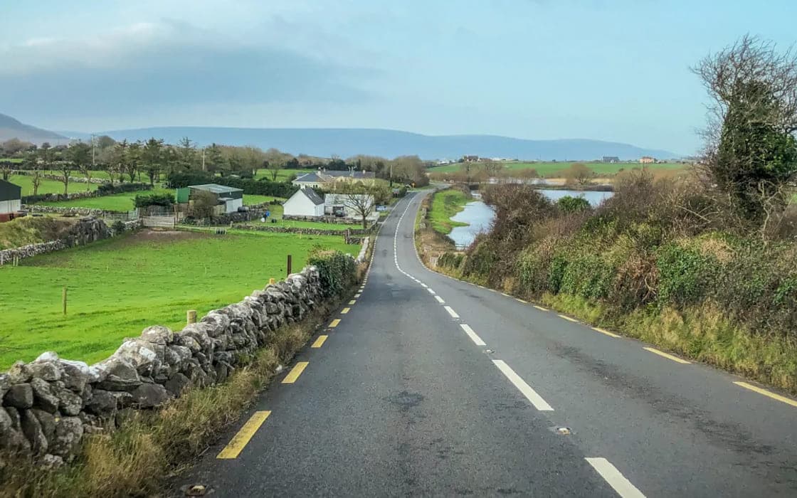 An empty road running between stone walls in the west of Ireland